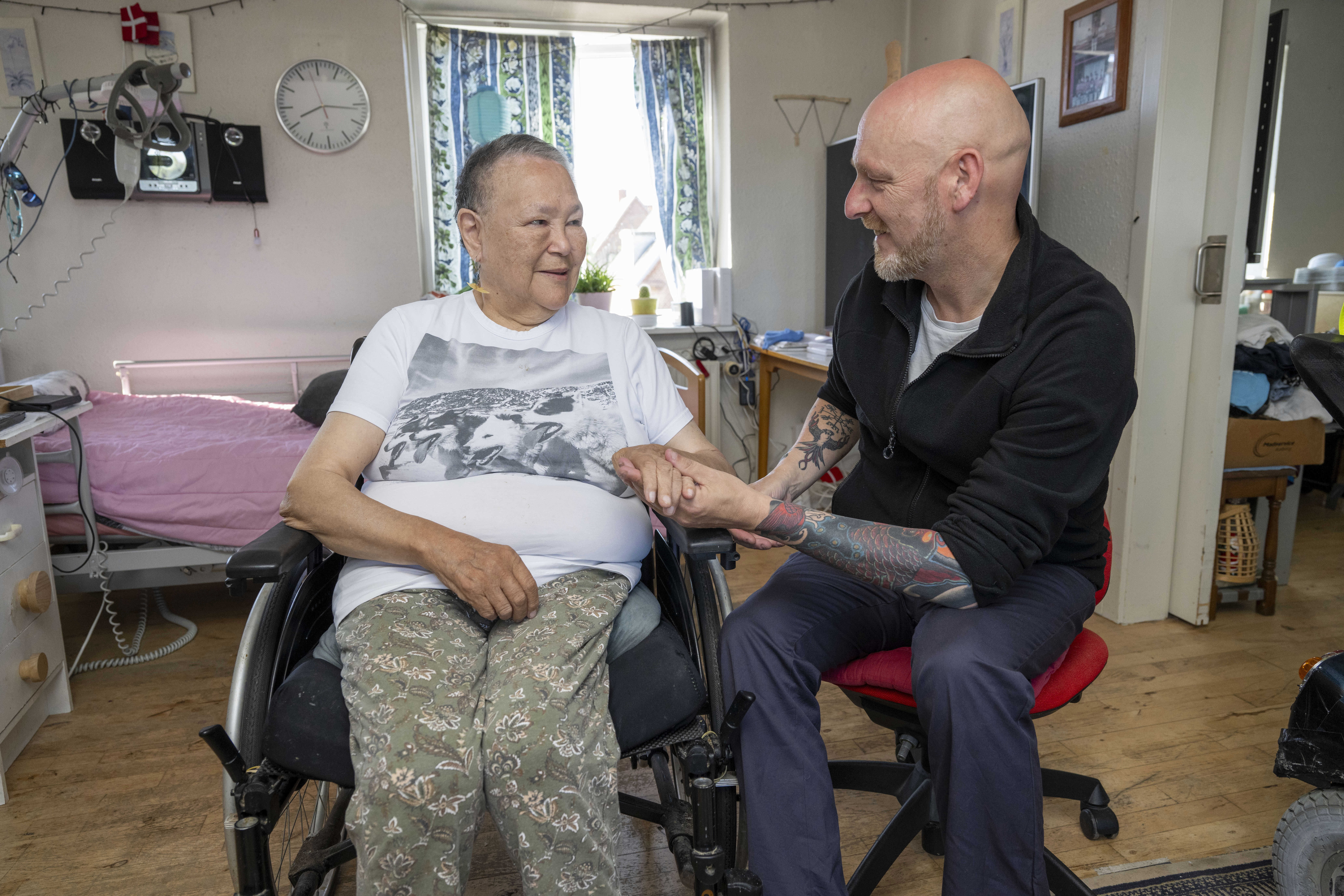 Person i kørestol bliver holdt i hånd