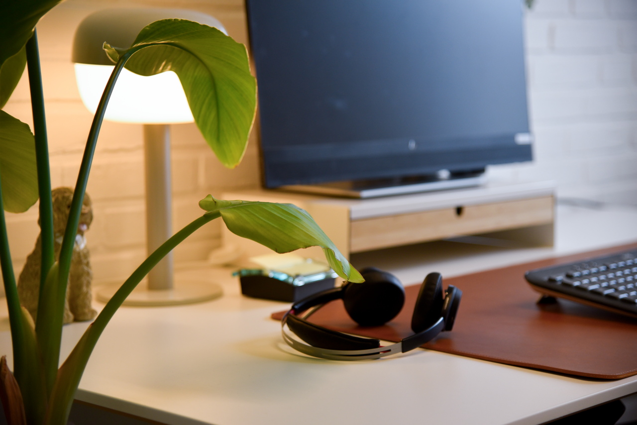 PC med ørebøffer på skrivebord