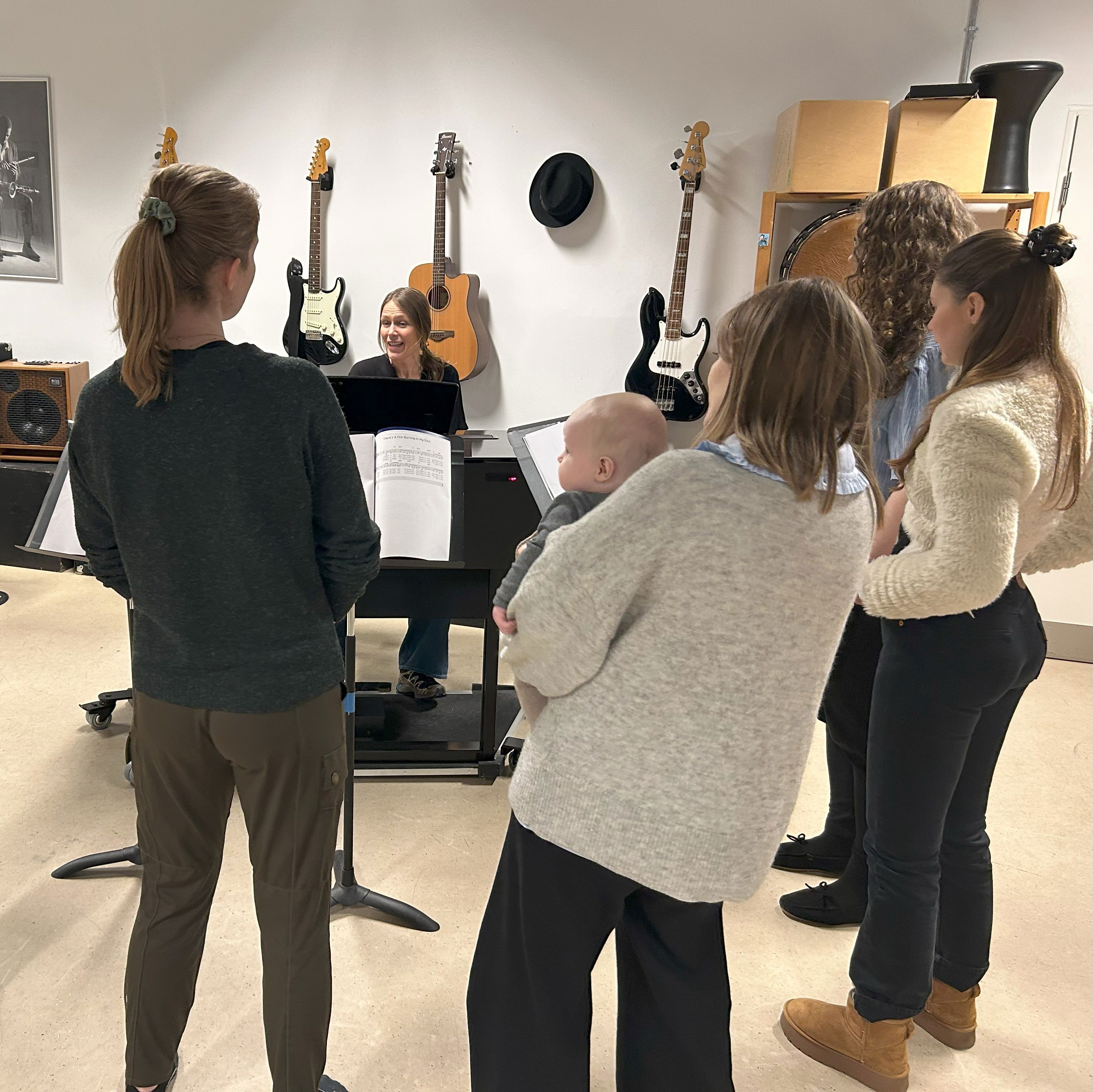 kvinder stående omkring klaver