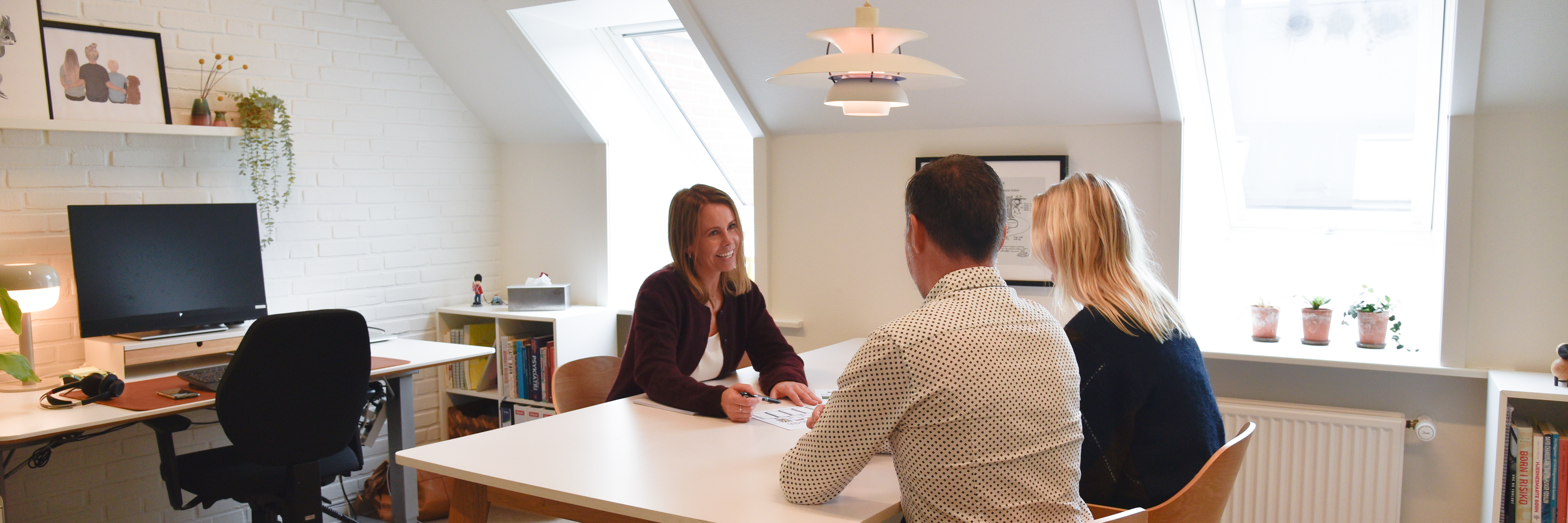 Tre mennesker, der sidder rundt om et bord