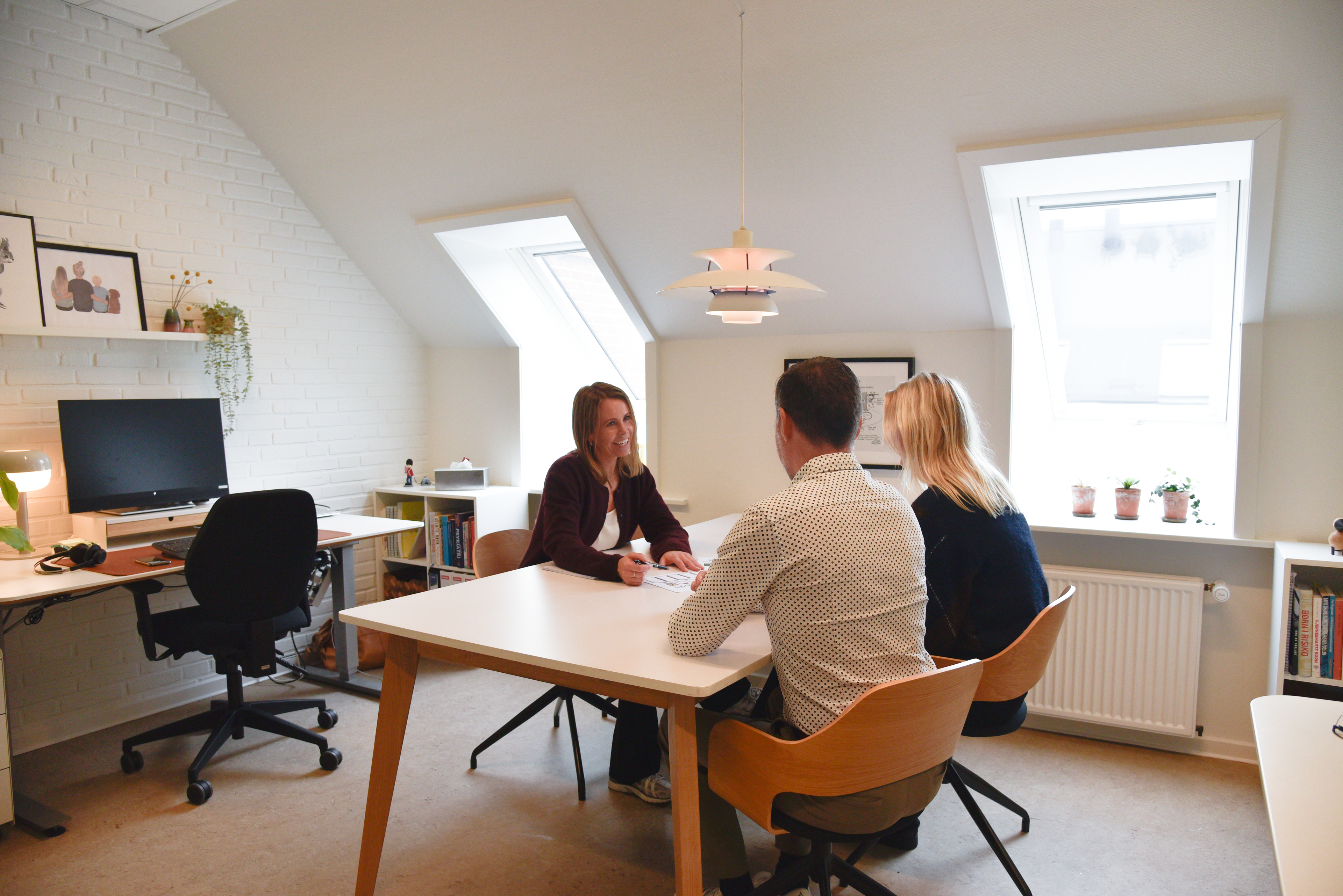 Tre mennesker, der sidder rundt om et bord