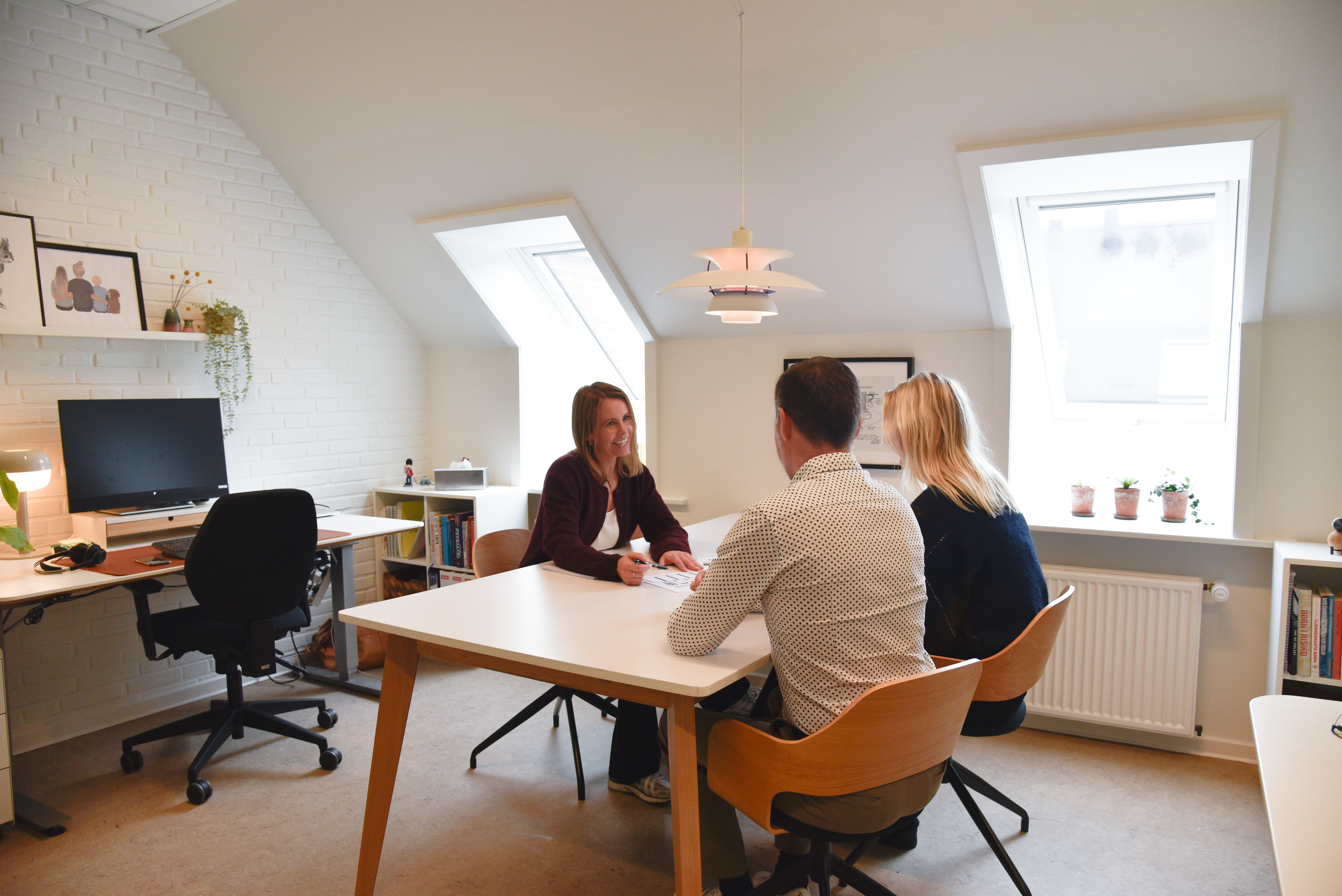 Tre mennesker, der sidder rundt om et bord