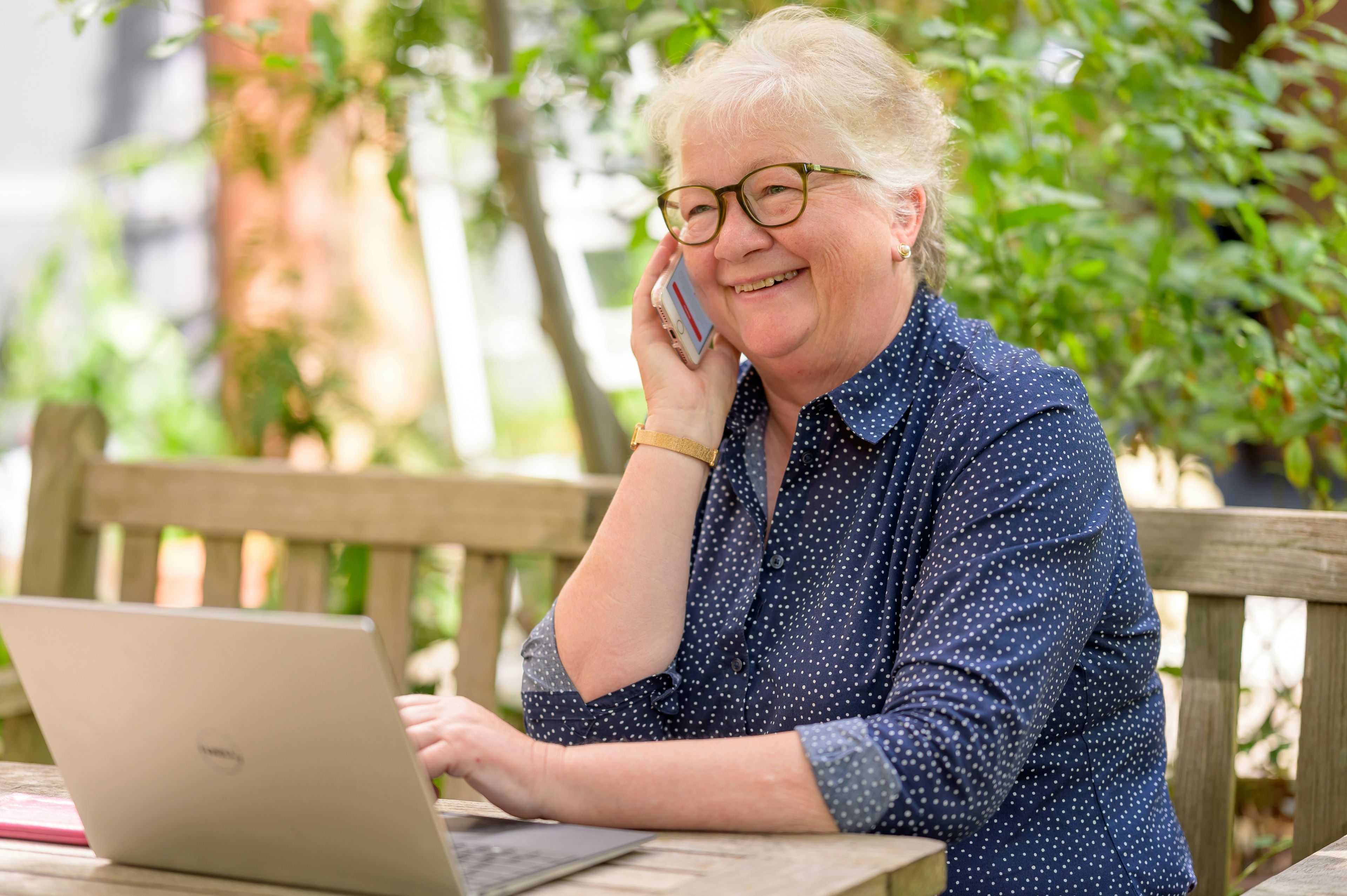 Dame taler telefon og arbejder ved pc