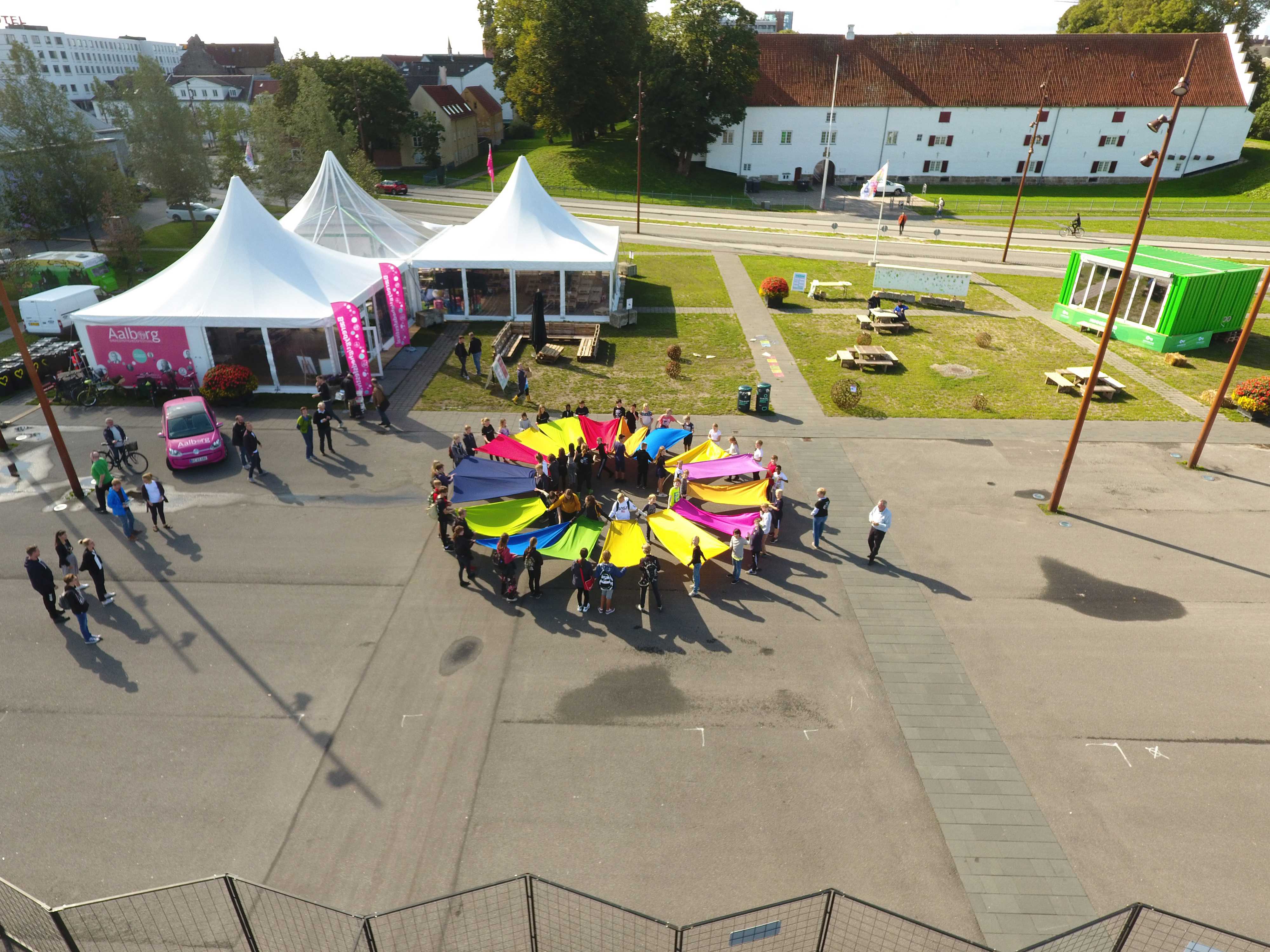 Mennesker, der holder flag i en cirkel, som danner FN's bæredygtighedsmål