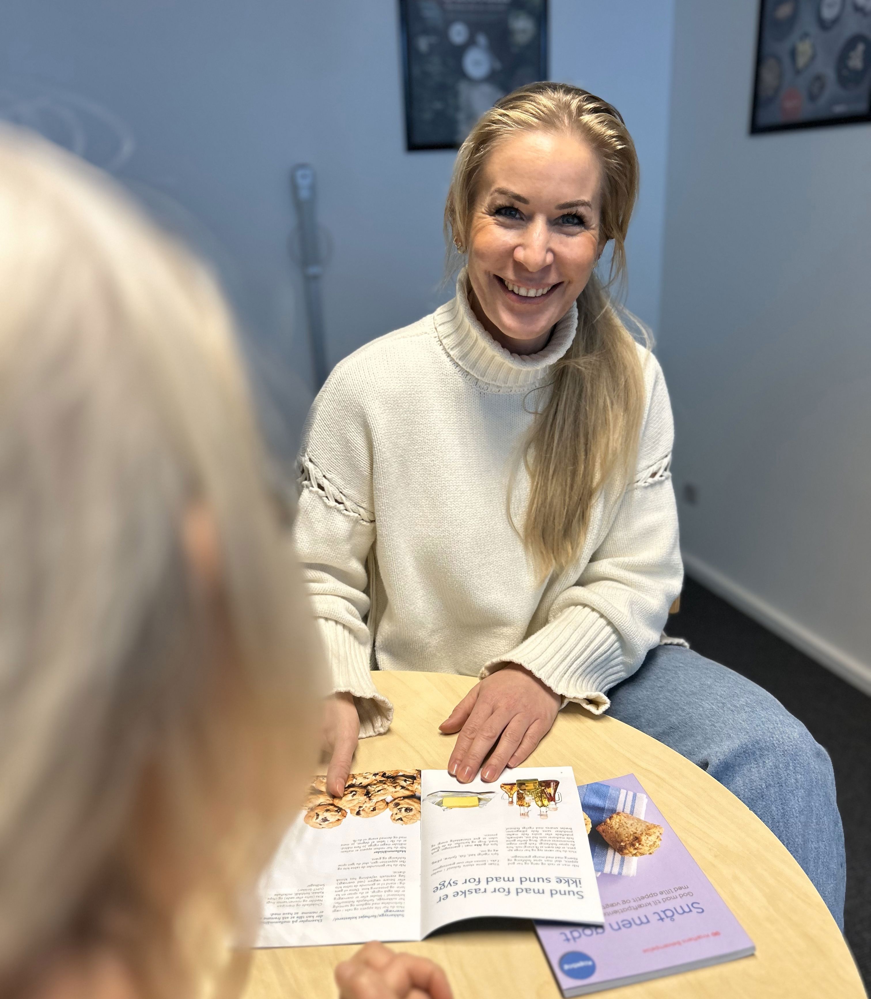 Siddende kvinder sidder med kostfolder