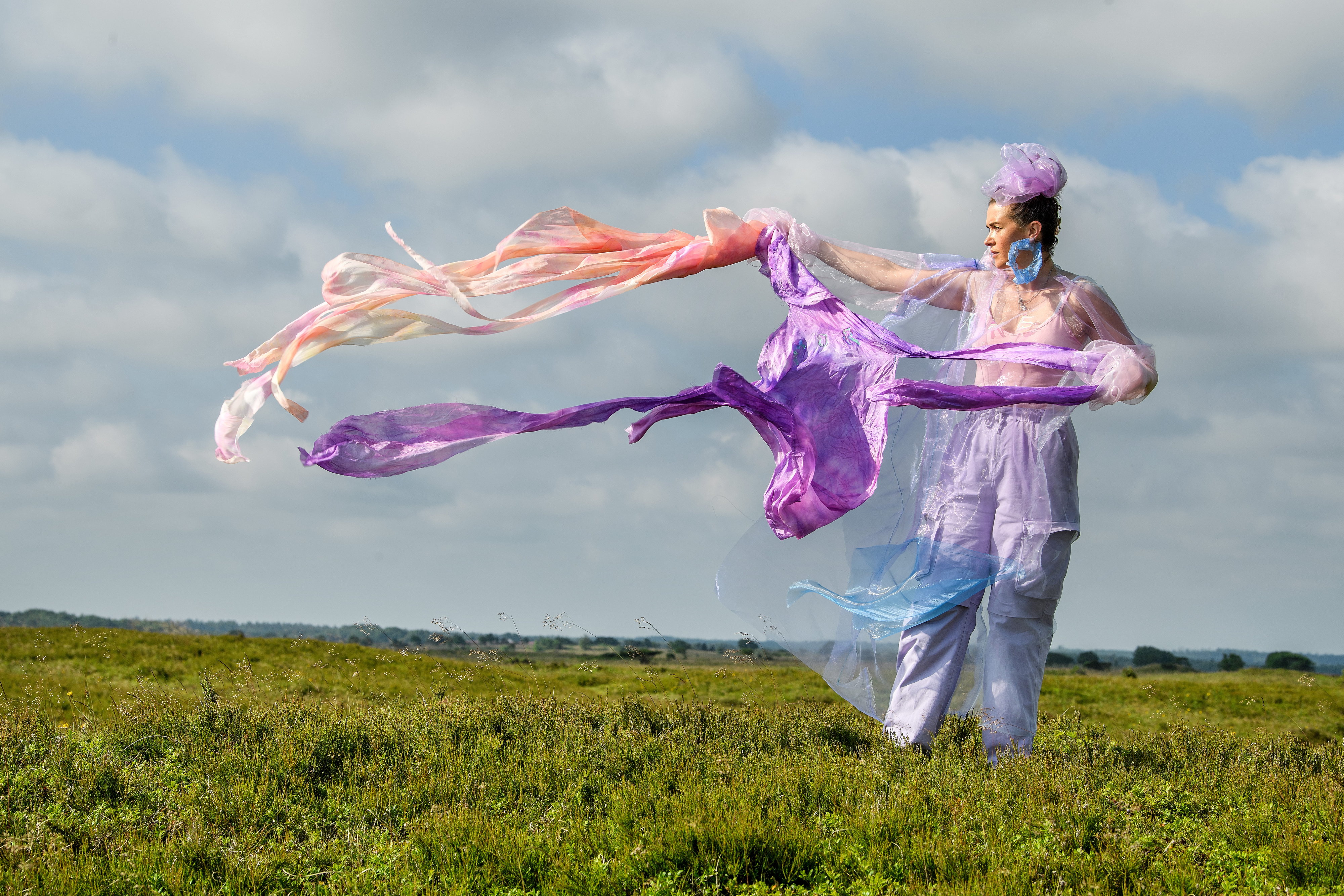 Kunstværket Walking Landscapes af Sonja Strange, der forestiller kvinde på græsmark med flyvende tørklæder.