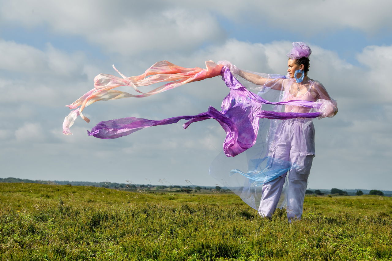 Kunstværket Walking Landscapes af Sonja Strange, der forestiller kvinde på græsmark med flyvende tørklæder.