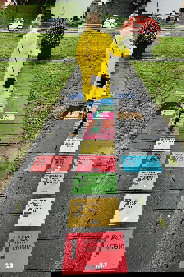 Pige i gul regnfrakke, der hopper i hinkerude på FN's Verdensmål