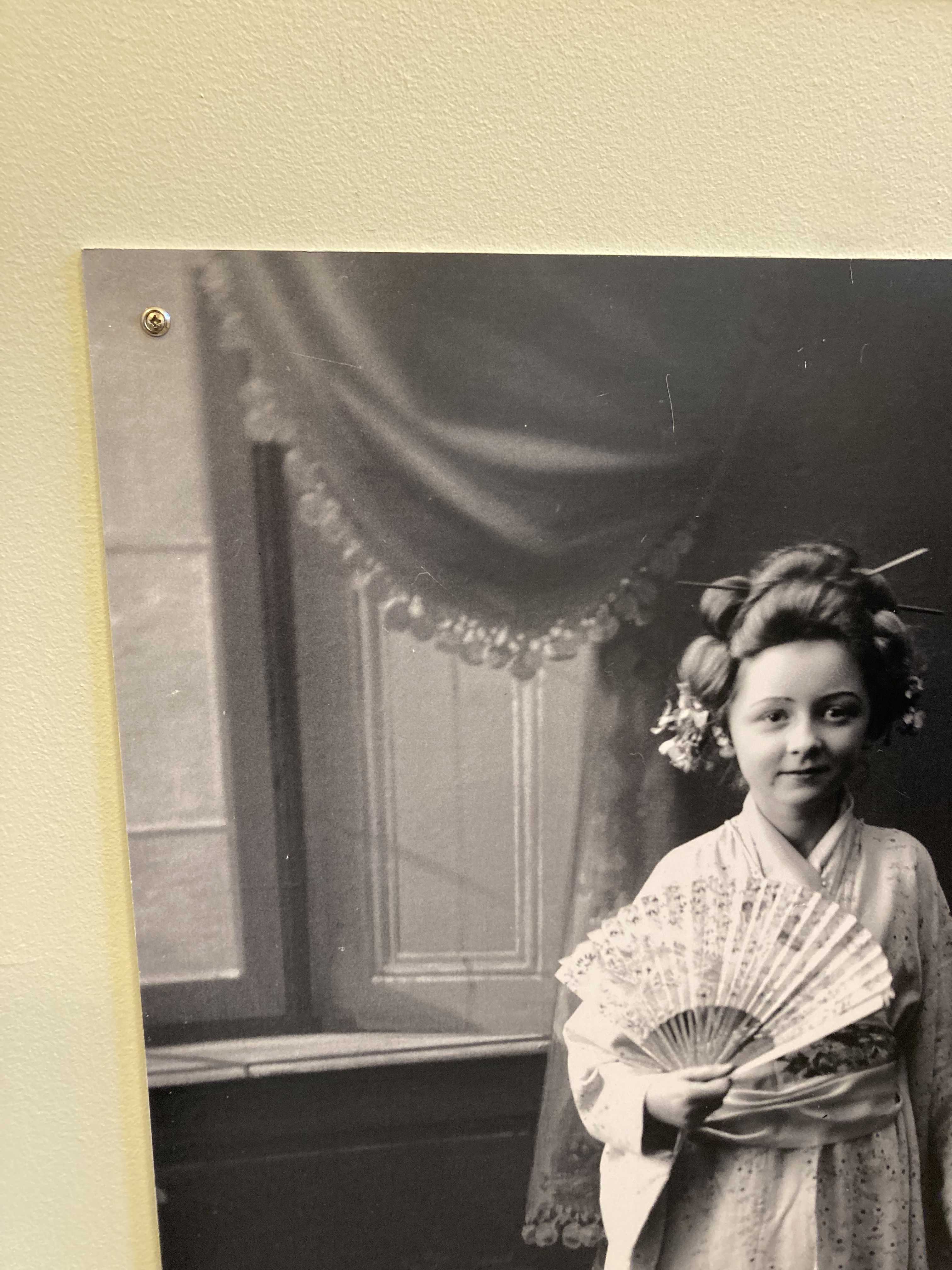 Gammel sort/hvid billede af ung pige i japansk kostume fra 1916.