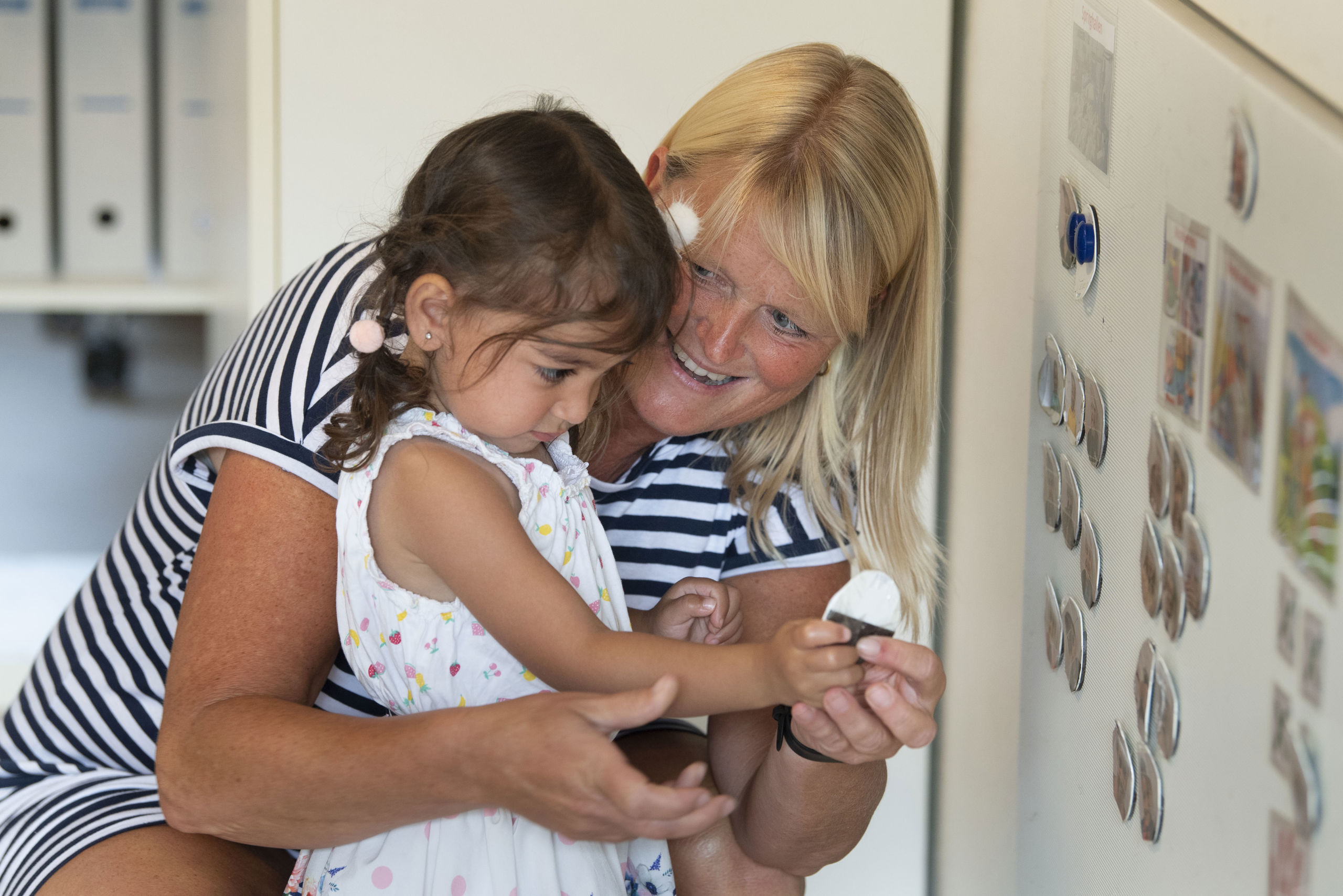 Pædagog og barn sidder sammen