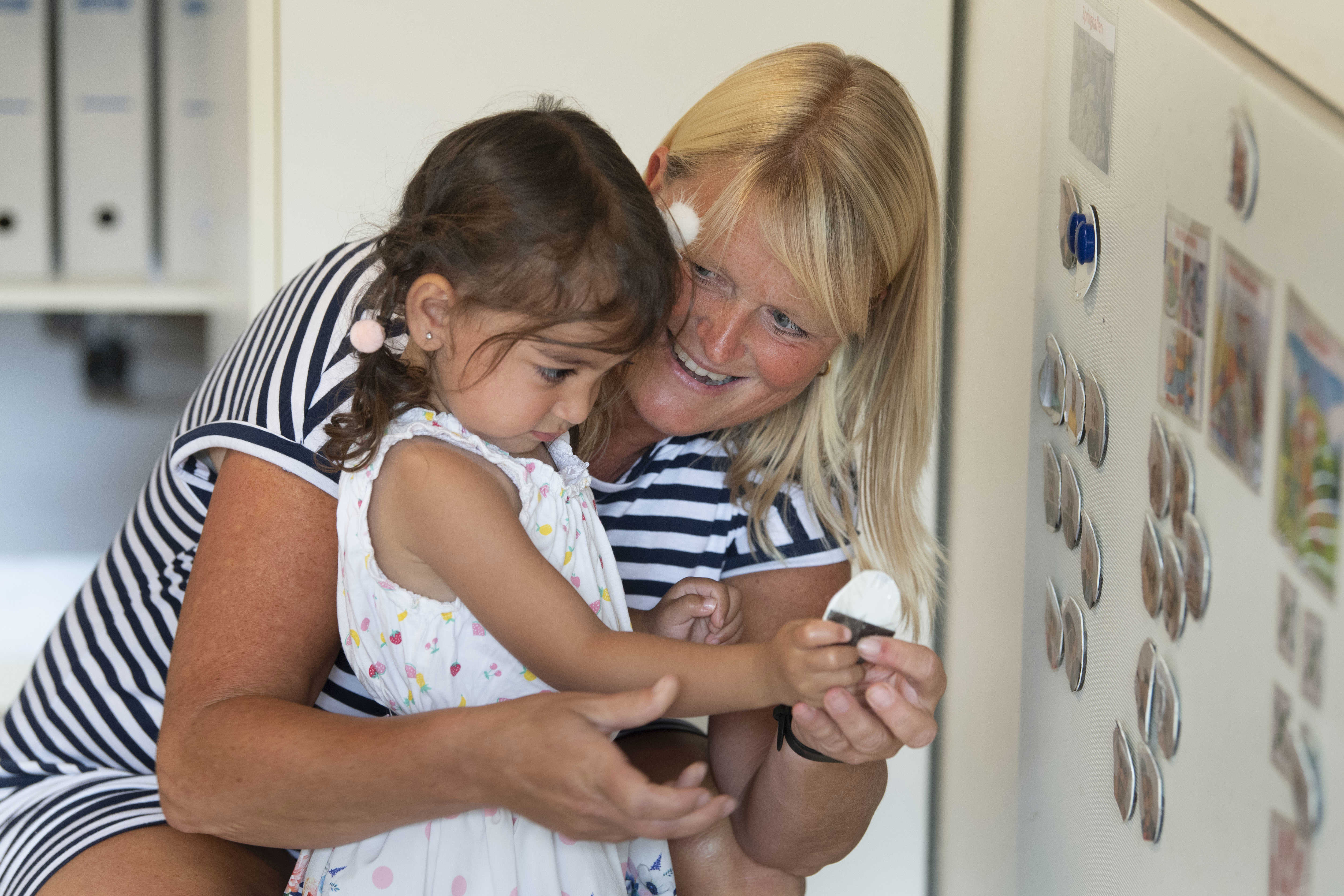 Pædagog og barn sidder sammen