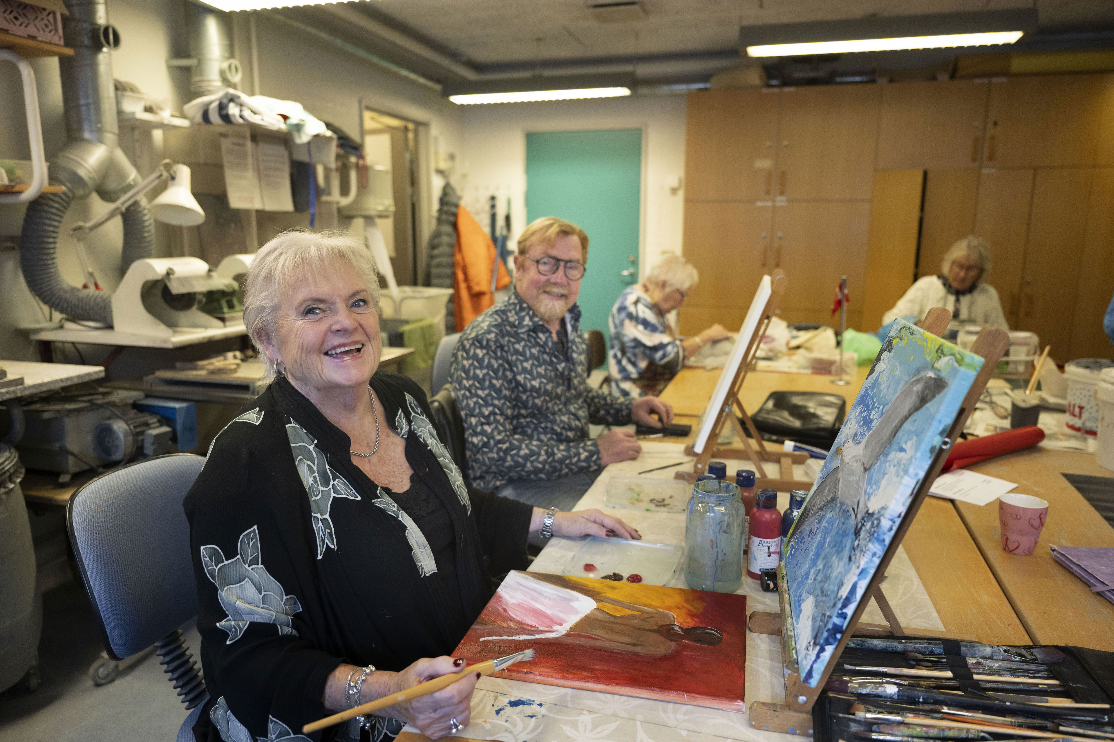 En kvinde og en herre maler på lærred