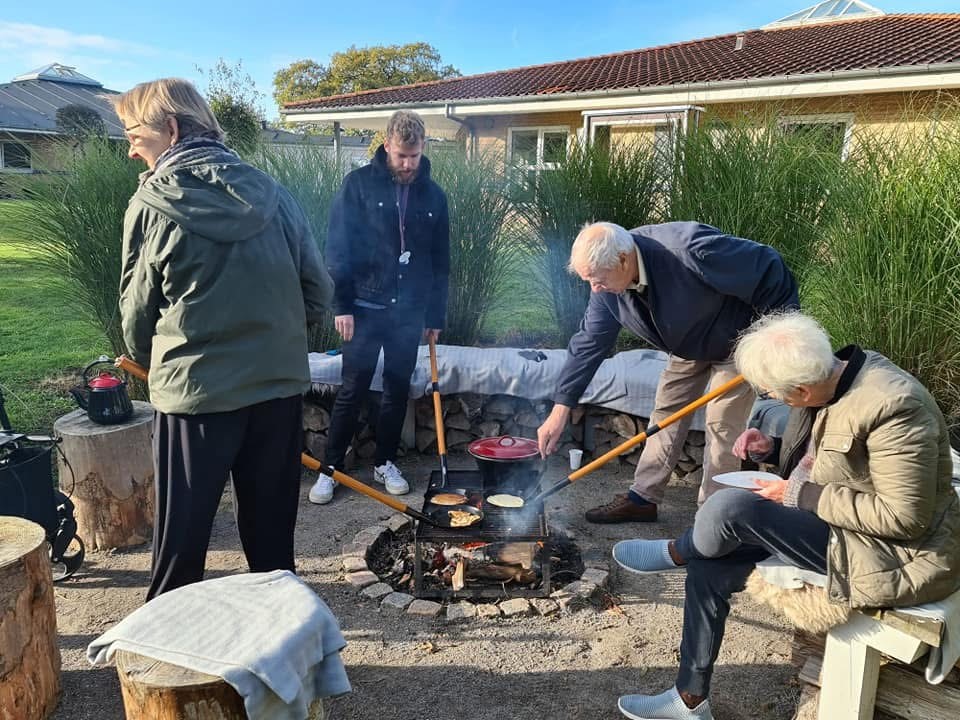 Fire personer laver mad over bål
