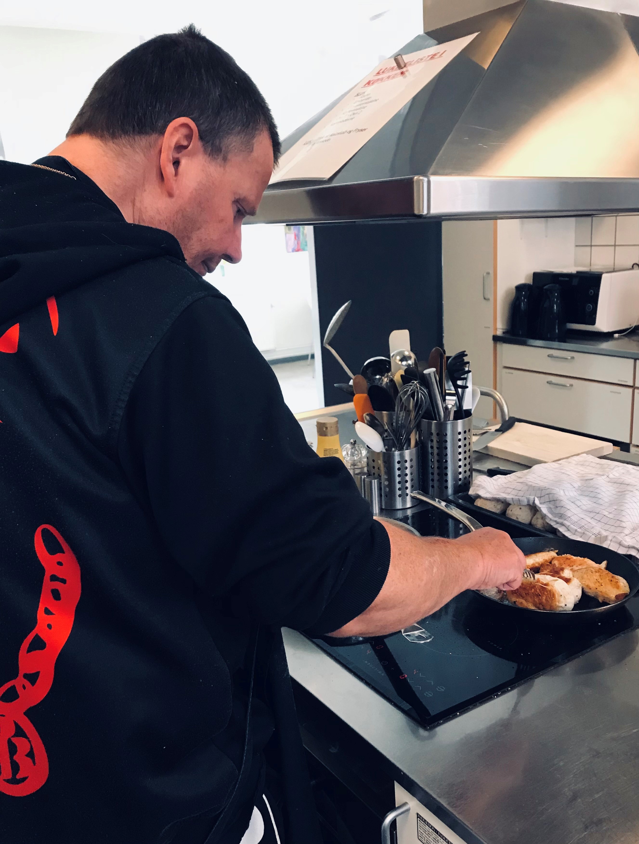 Mand steger kyllingefilet på en pande