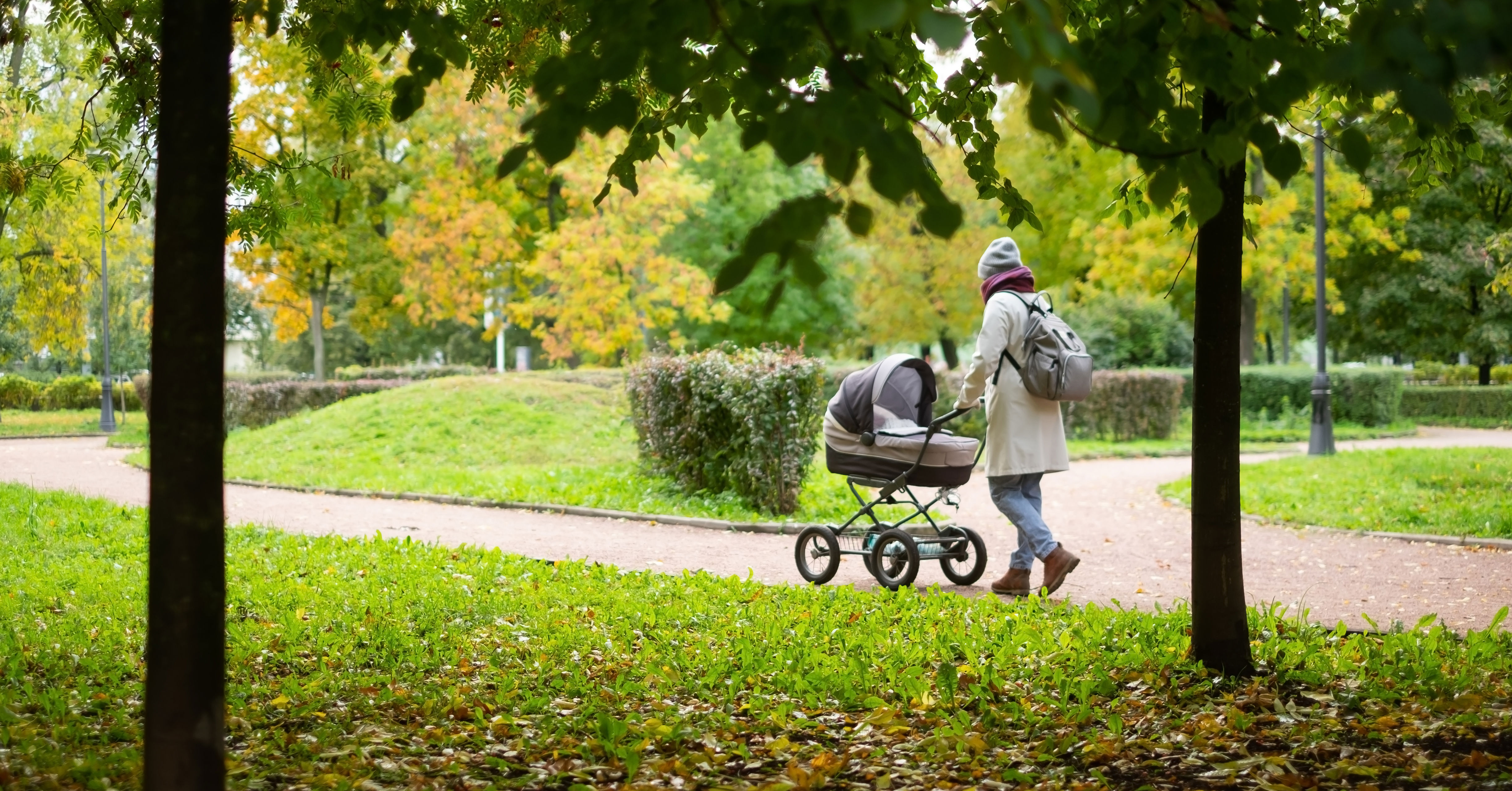 Kvinde der går med barnevogn