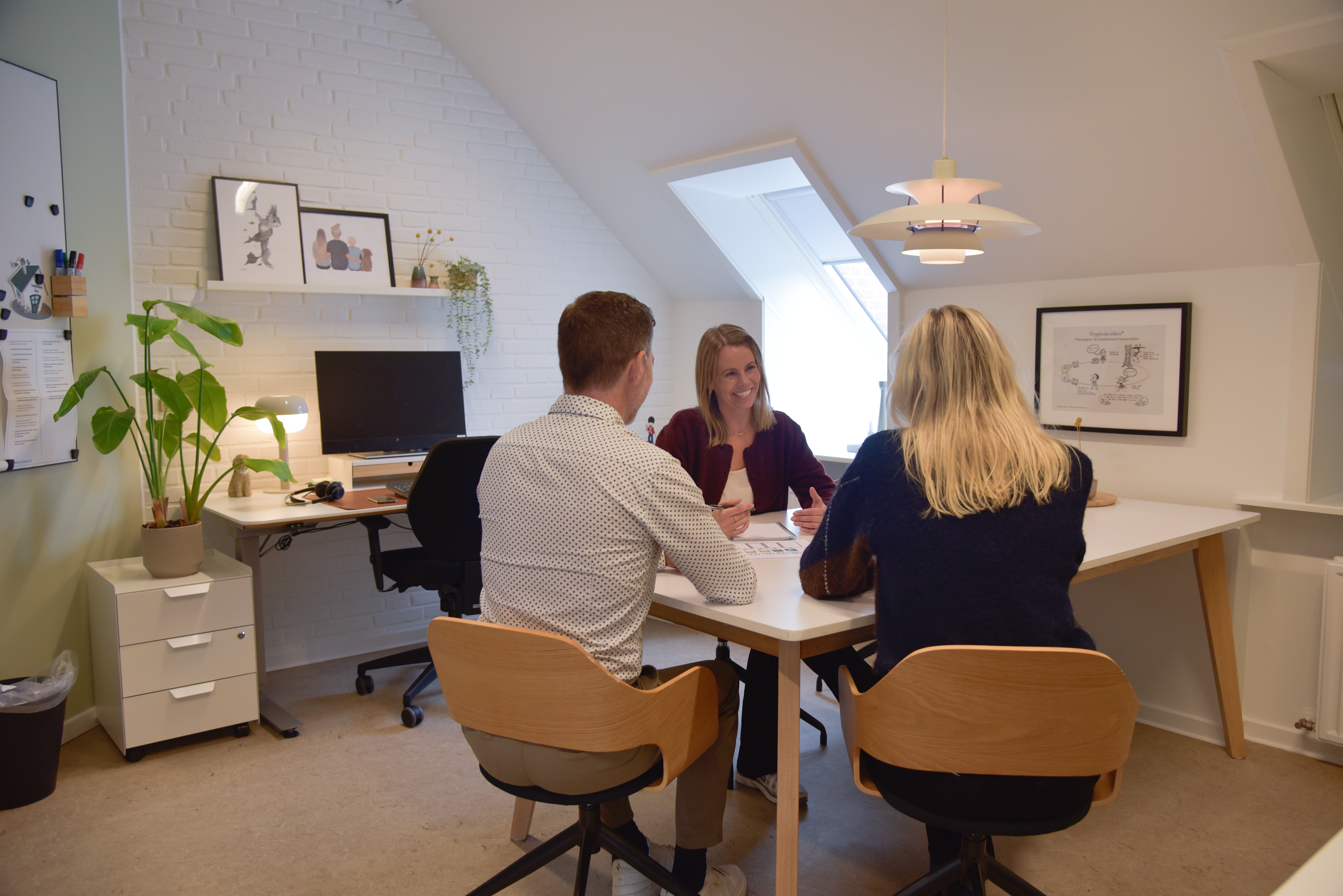 rådgiver i samtale med forældre ved et bord