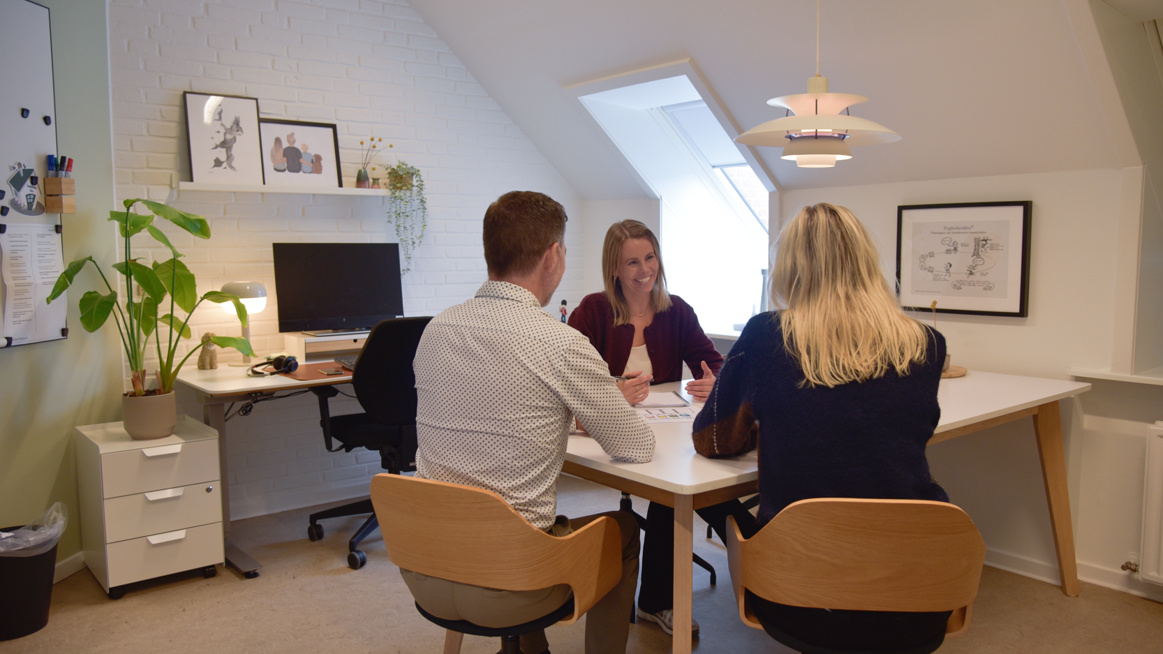 rådgiver i samtale med forældre ved et bord