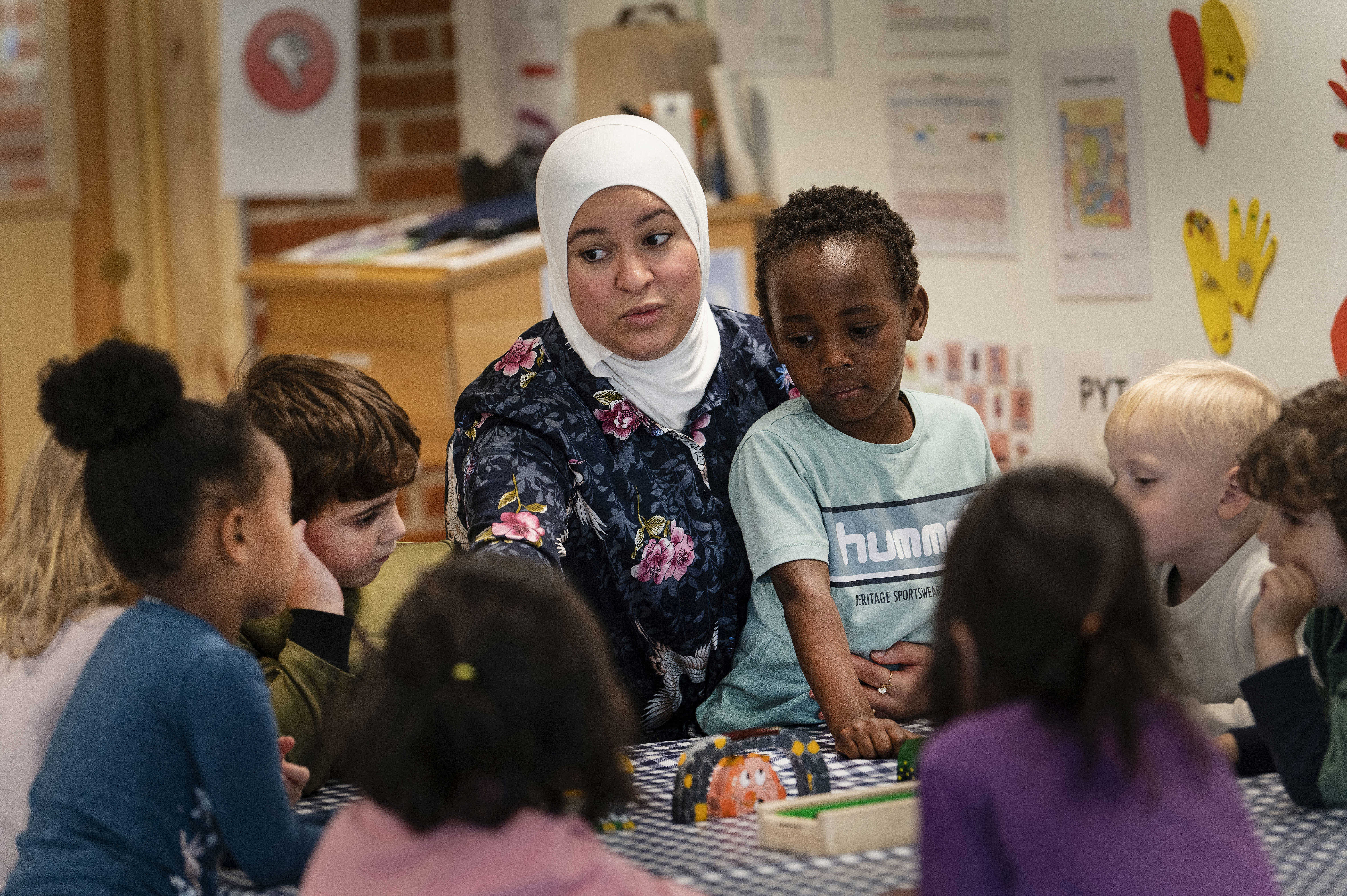 Pædagog sidder med en gruppe børn