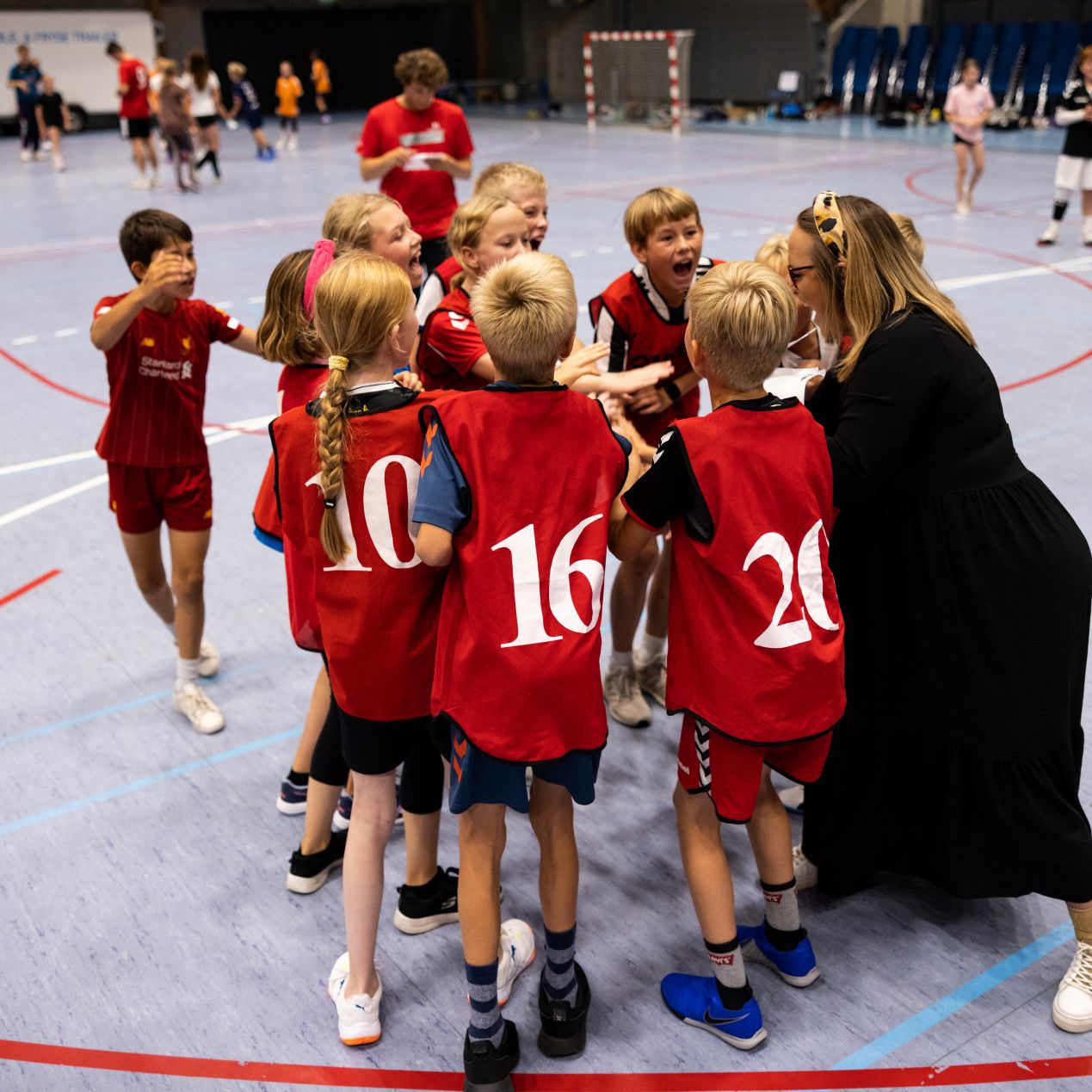 Børn og træner hepper på hinanden før kamp