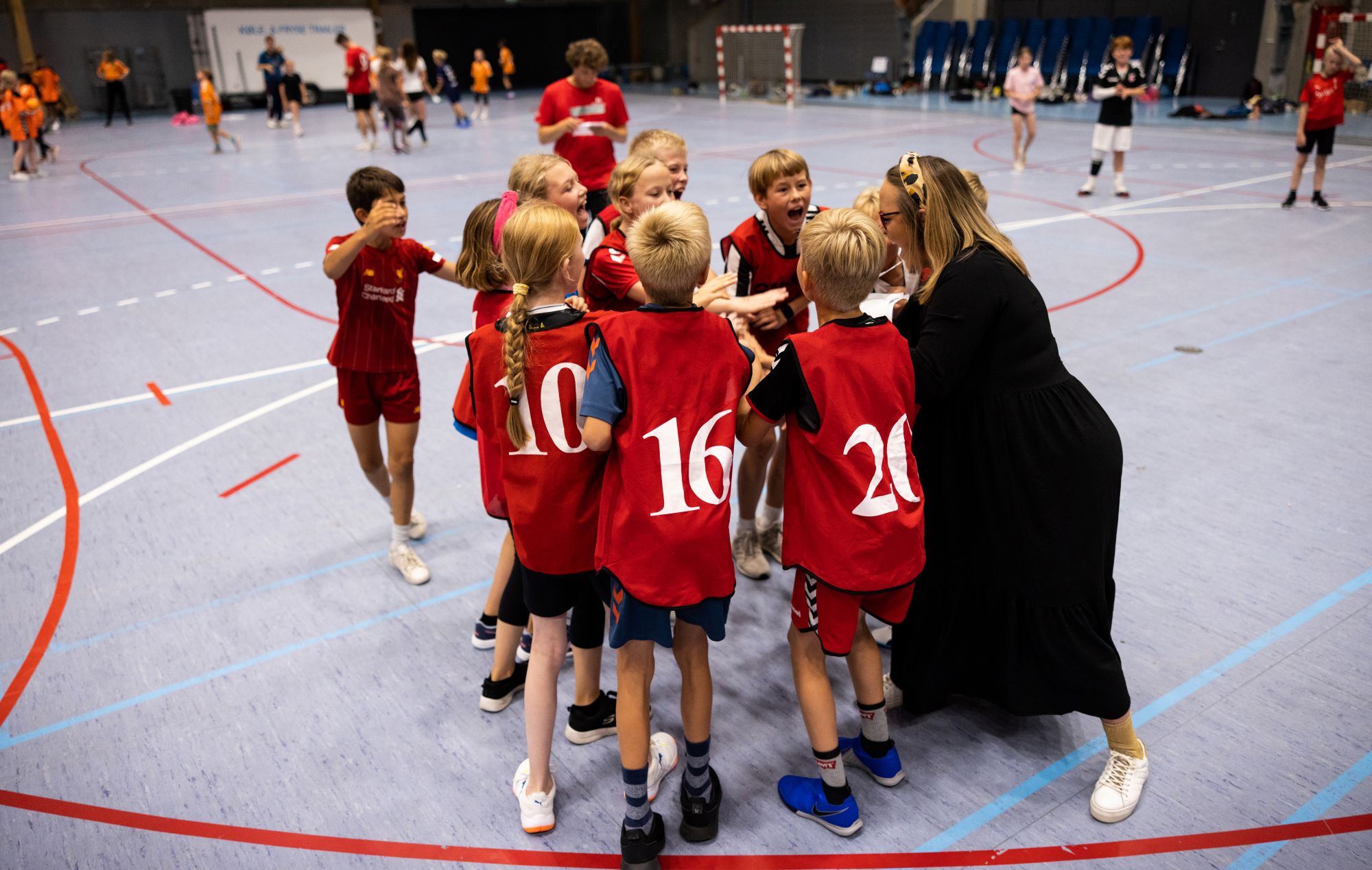 Børn og træner hepper på hinanden før kamp