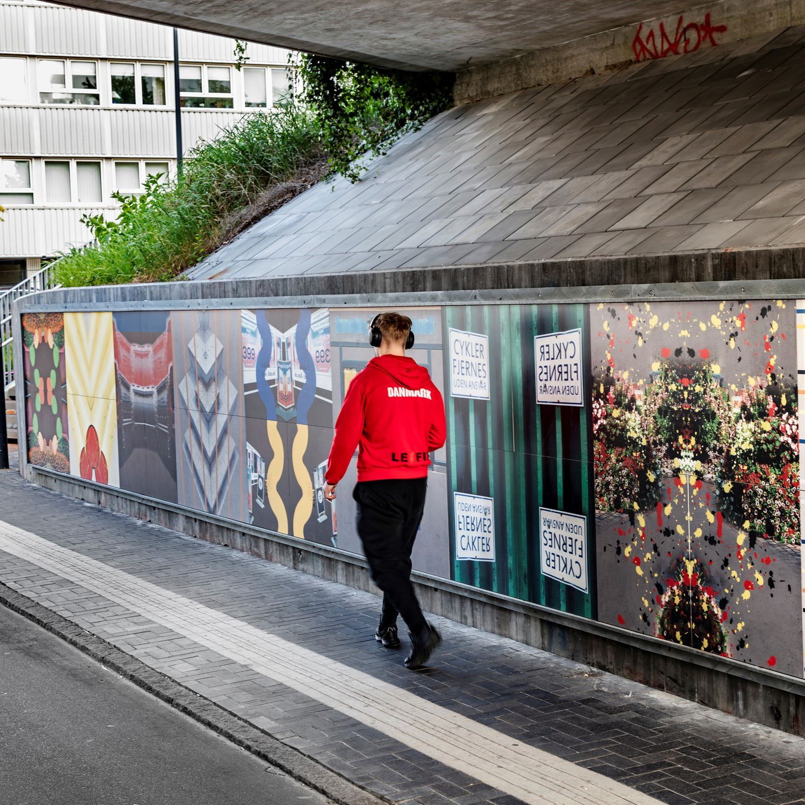 Mand i rød trøje går forbi City Quilt